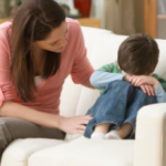 Adult comforting a child on the couch